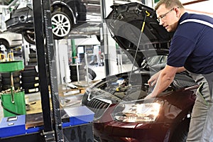 adjusting the headlights on the car by mechanics in a garage