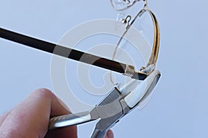 Adjusting inclination of temples on modern metal eyeglass frame with conical inclination pliers