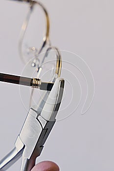 Adjusting inclination of temples on modern metal eyeglass frame with conical inclination pliers