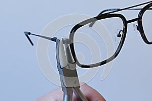 Adjusting inclination of temples on modern plastic and metal eyeglass frame with conical inclination pliers