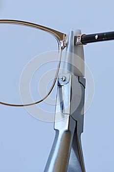 Adjusting inclination of temples on modern plastic and metal female eyeglass frame with conical inclination pliers