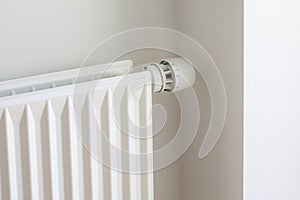 Adjusting knob on thermostat on radiator valve to save energy