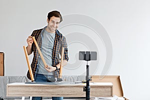 Adjusting or repair chair, worker fixing, assembling wooden stool with electric screwdriver