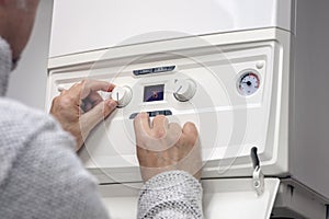 Adjusting thermostat setting on home heating system central heating boiler