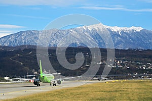 Adler, Russia. Travel. Airfield view. Sochi International airport. Green grass between runways and beautiful mountains on