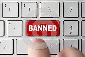 admin bans the user. red button on the keyboard of a notebook with the inscription of banned. concept of blocking in the Internet