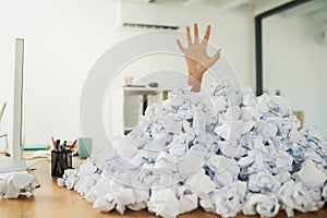 Admin can be overwhelming once it piles up. an unidentifiable businesswoman drowning under a pile of paperwork in the