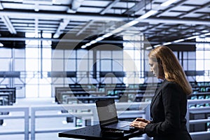 Admin in data center using laptop to visualize artificial intelligence