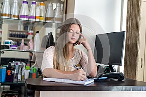 Administrator in beauty salon making notes to planner