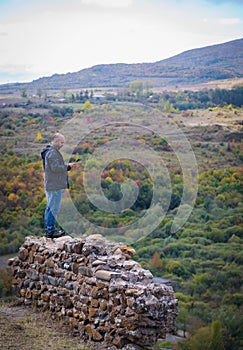 Admiring the Scenic Mountain View: Man standing on Ruined Fortress Wall