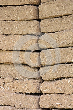 Old adobe brick wall with straw