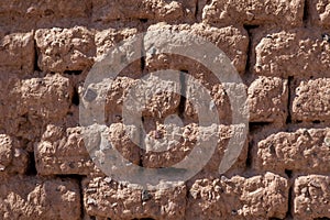 An adobe brick wall in sunny floodlight