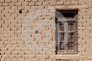 An adobe brick wall with a window