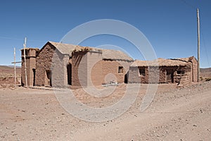 Adobe house in Cerrillos village on Bolivian Altiplano near Eduardo Avaroa Andean Fauna National Reserve with blue sky, Bolivia