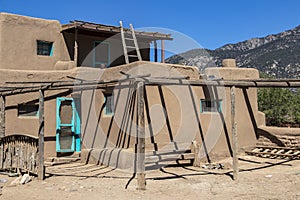 Adobe Mud multi-storied buildings in pueblo village that have been continuously inhabited for over 1000 years with New Mexico moun