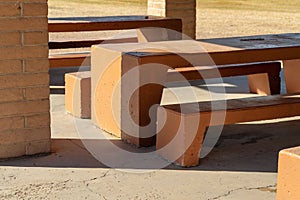 Adobe red or orange bench in late afternoon shadow in a dining area where people can picnic and have lunch