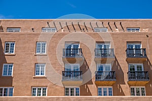 Adobe structure with rows of windows and balconies.