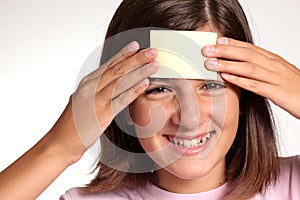 Adolescent face with a blank yellow sticky note