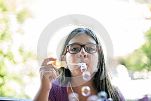 Adolescent girl blowing bubbles on the balcony