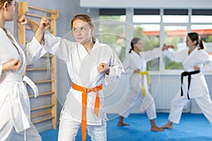 Adolescent girl honing punching techniques during kumite at karate training