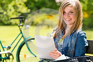 Adolescent girl using tablet computer in park photo