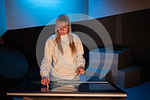 Adolescent girl using touch screen display on museum exhibition