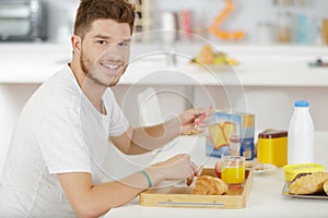 Adolescent male having breakfast at home