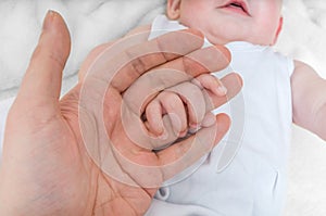 Adoption baby concept. Man holds little child's hand photo
