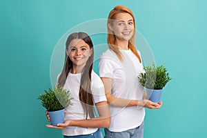 Adoptive family of adopted daugher child and woman mother smile holding pot plants, foster