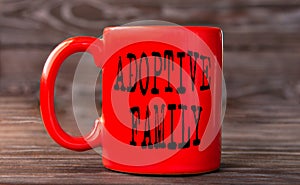 ADOPTIVE FAMILY - word on a red cup on a dark background