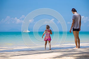 Adorabel daughter and father on sand beach of ocean