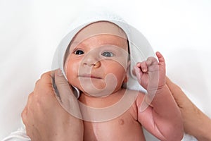 Adorable 2 months old little baby boy on towel after bath in his mother`s hands