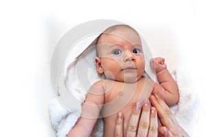 Adorable 2 months old little baby boy on towel after bath in his mother`s hands