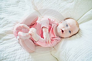 Adorable 4 months old baby girl lying on bed