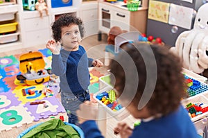 Adorable african american boys playing with construction blocks and soap bubbles at kindergarten