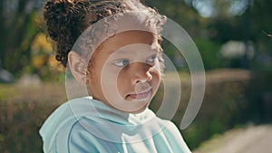 Adorable african american child portrait standing with mother at sunny park.