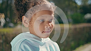 Adorable african american child portrait standing with mother at sunny park.