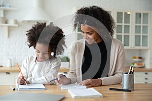 Adorable african american girl enjoying studying with mommy.