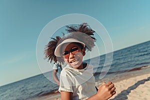 adorable african american girl in sunglasses running