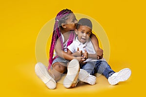 Adorable african american siblings sitting on floor and cuddling