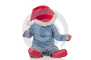 Adorable african baby with Christmas hat covering his face