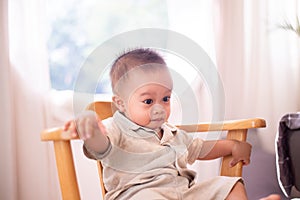 Adorable asian baby boy sitting on chair in bedroom,Happy new born kid