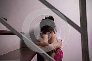 Adorable asian girl who expresses her sadness emotion on house stair alone shows concept of depression, emotional pain and
