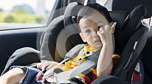 Adorable Asian kid boy Toddler age 1-year-old Protection Sitting in the Car Seat with Safety Belt Locked