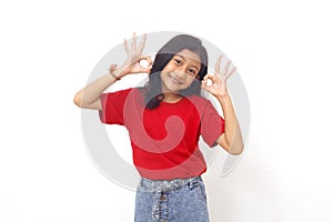 Adorable asian little girl standing while showing OK hand gesture. Isolated on white background