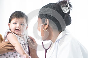 Adorable Asian newborn baby three months old girl check up examines by pediatrician. Doctor using stethoscope examining little