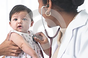 Adorable Asian newborn baby three months old girl check up examines by pediatrician. Doctor using stethoscope examining little