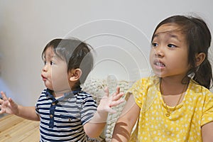 Adorable asian siblings being playful at their home