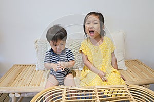 Adorable asian siblings being playful at their home