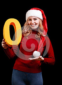 Beautiful Santa girl holding a yellow zero number on a black background. Christmas 2018 concept.